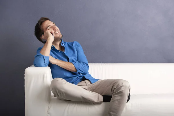 Man with phone  relaxing on couch — Stock Photo, Image