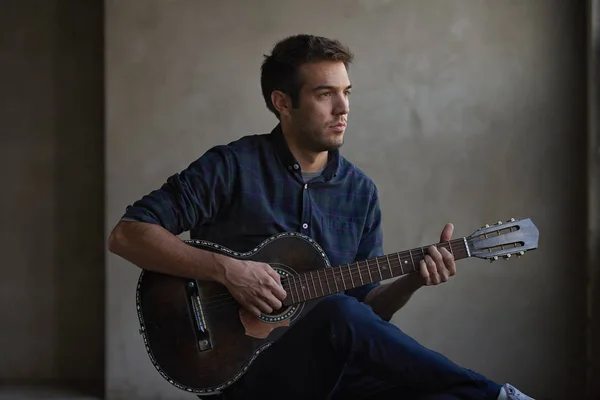 Músico tocando em sua guitarra acústica . — Fotografia de Stock