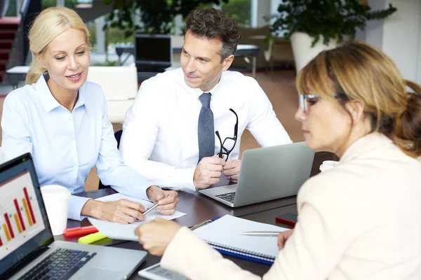 Vrouwelijke ondernemers en zakenman achter het bureau zit — Stockfoto