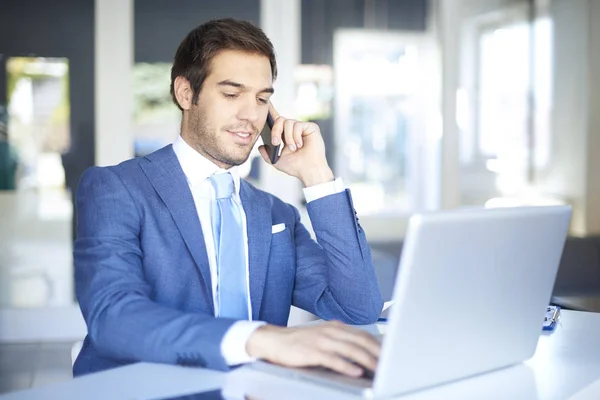 Empresário fazendo chamada enquanto sentado — Fotografia de Stock