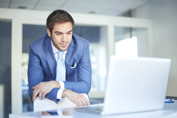 Empresário em pé no seu posto de trabalho . — Fotografia de Stock