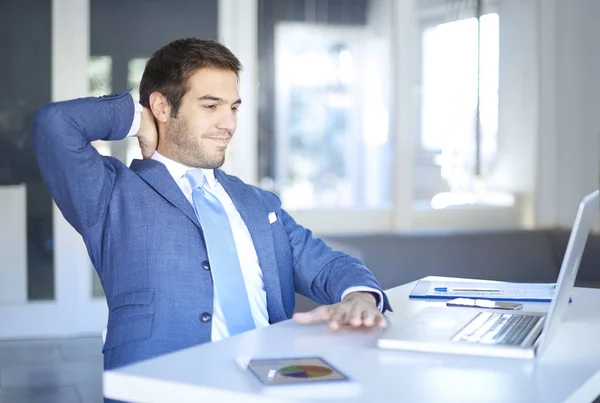 Jovem empresário satisfeito sentado — Fotografia de Stock