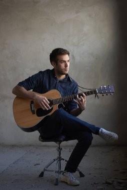  Adam akustik gitar çalıyor.