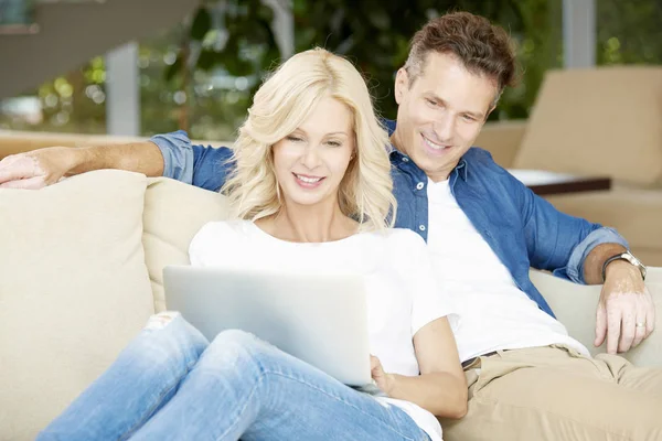 Casal sentado com um laptop em casa — Fotografia de Stock