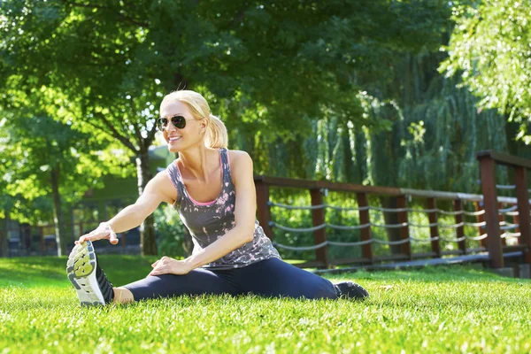 Vrouw zitten en die zich uitstrekt — Stockfoto