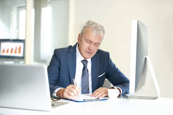 Empresário financeiro sentado em seu escritório — Fotografia de Stock