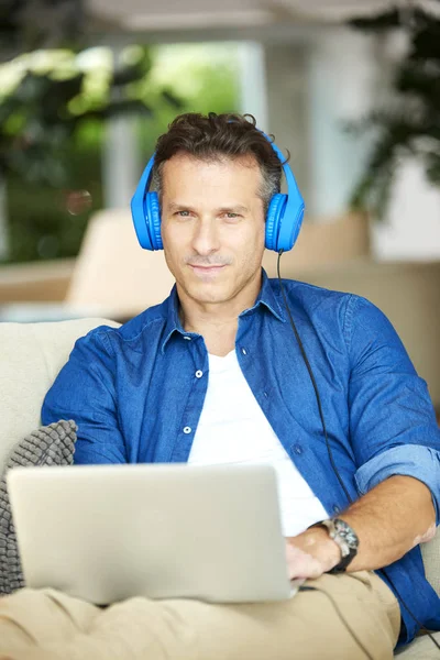 Homem sentado em casa e usando seu laptop — Fotografia de Stock