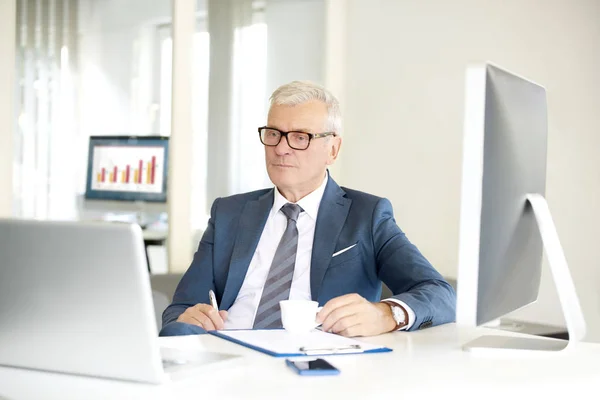 Alto empresário financeiro sentado — Fotografia de Stock