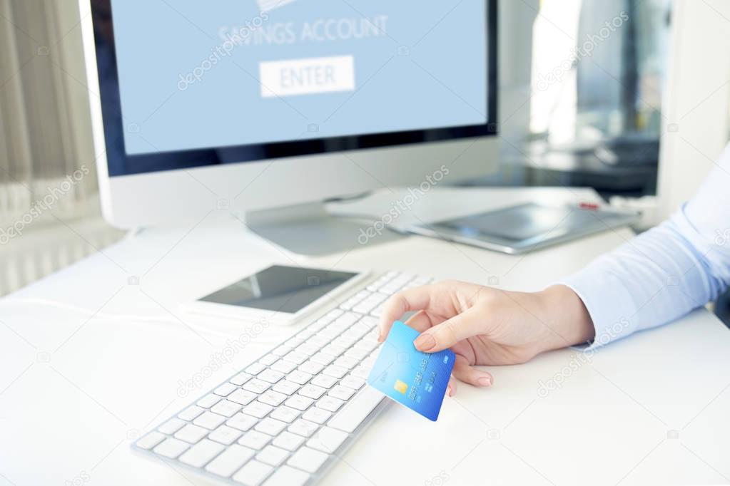 Close-up shot of a businesswoman holding bank card and banking online.