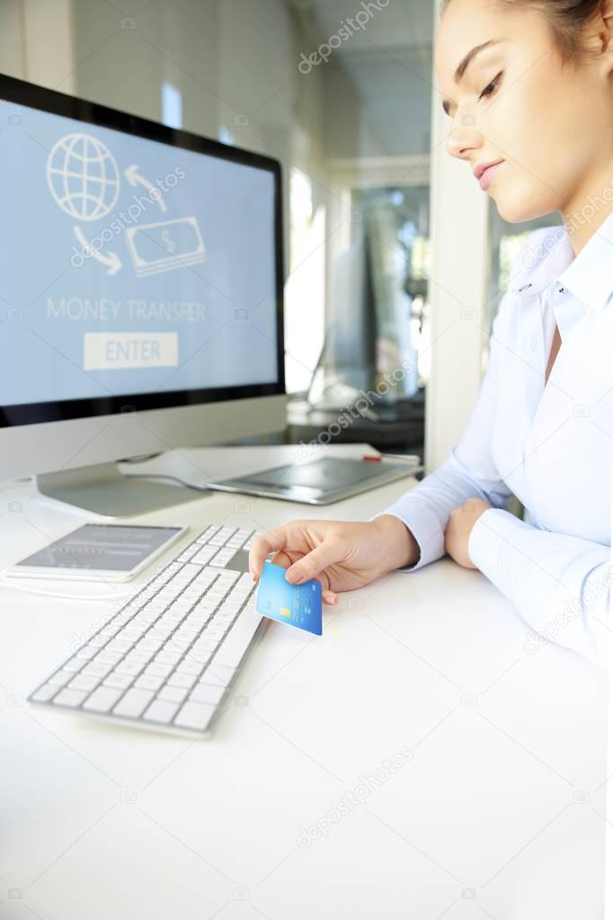 Shot of a businesswoman  holding bank card and making online payments by credit card.