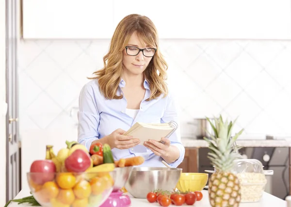 Woman reading her recipe book — Stock Photo, Image