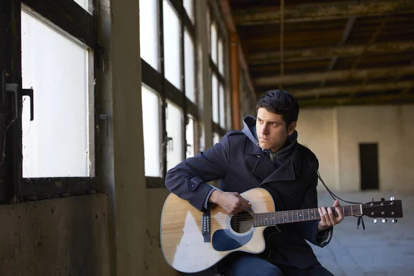 Ung man spelar sin gitarr. — Stockfoto