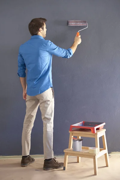 Hombre usando rodillo de pintura — Foto de Stock