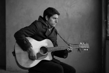 genç adam onun akustik gitar çalmak. 
