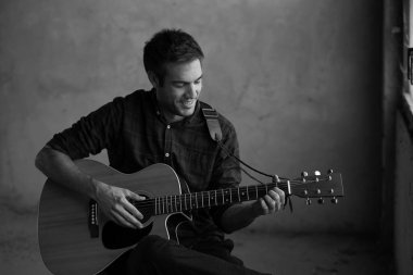 genç adam onun akustik gitar çalmak. 