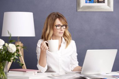  çay içme ve dizüstü kullanan kadın