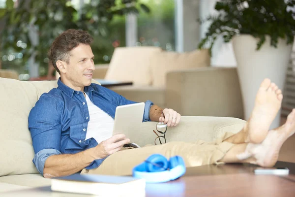 Mann benutzt sein Tablet beim Entspannen — Stockfoto