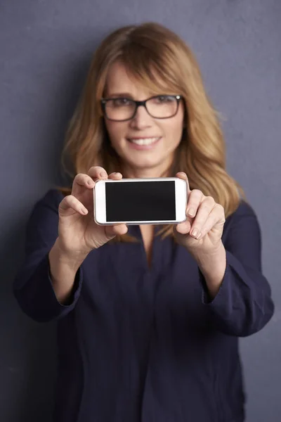 Vrouw toont haar nieuwe mobiele telefoon — Stockfoto