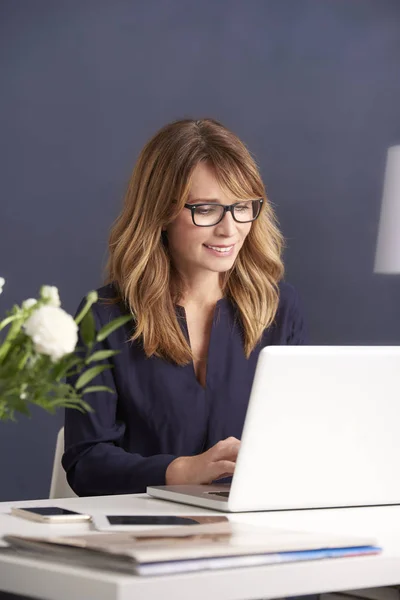 Lächelnde Frau tippt auf Laptop — Stockfoto