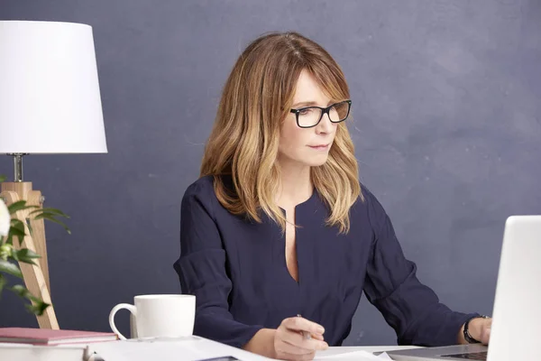 Zakenvrouw werkt aan haar laptop — Stockfoto