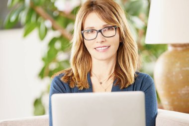 Dizüstü bilgisayar kullanan orta yaşlı kadın