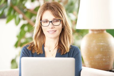 Dizüstü bilgisayar kullanan orta yaşlı kadın