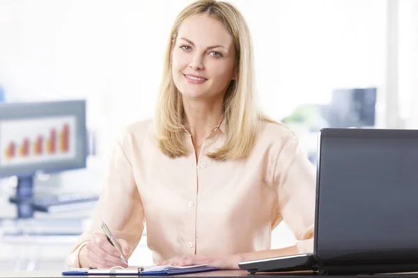 Affärskvinna som sitter framför en bärbar dator — Stockfoto
