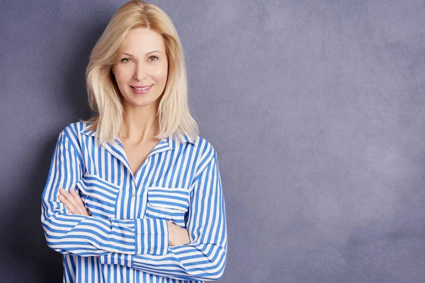 Blond woman standing with folded arms — Stock Photo, Image