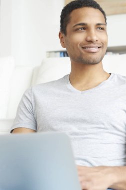 Genç adam laptopunu kullanıyor.
