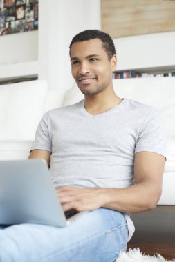  Genç adam laptopunu kullanıyor.