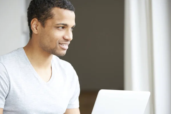 Junger Mann benutzt seinen Laptop — Stockfoto