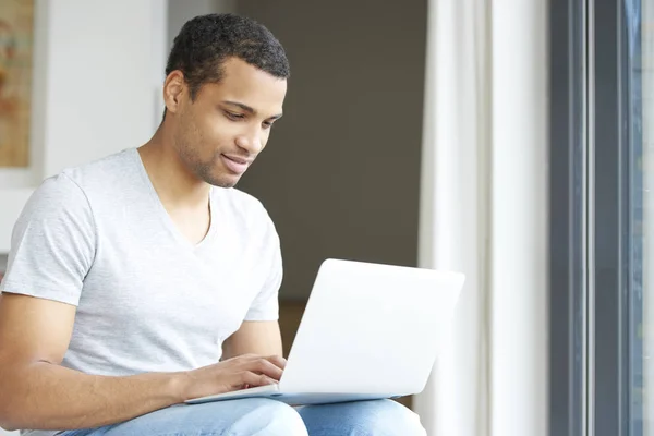 Young man using his laptop — Stock Photo, Image