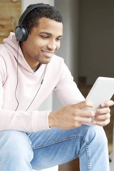 Mannen med tablett lyssnar på musik — Stockfoto