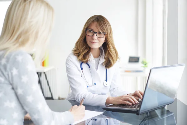 Doctor sitting in front of laptop — Stock Photo, Image