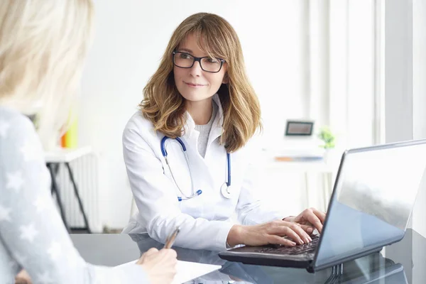 Läkare som sitter framför laptop — Stockfoto