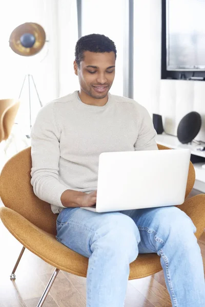 Un jeune homme utilisant un ordinateur portable — Photo