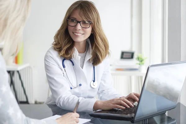 Lekarz siedzi przed laptop — Zdjęcie stockowe