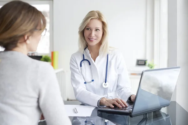 Läkare som sitter framför laptop — Stockfoto