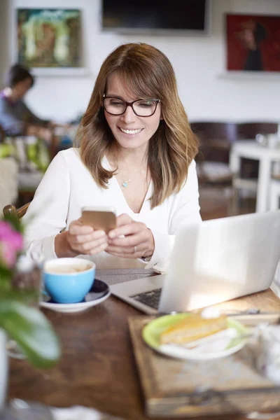 Vrouw achter laptop zit — Stockfoto