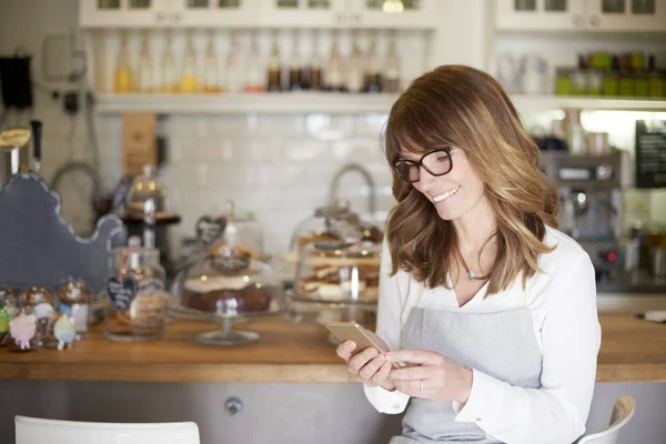 Eigenaar met haar mobiel — Stockfoto