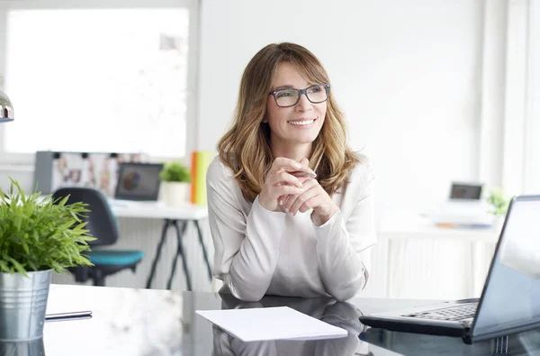 Empresária sentada no escritório — Fotografia de Stock