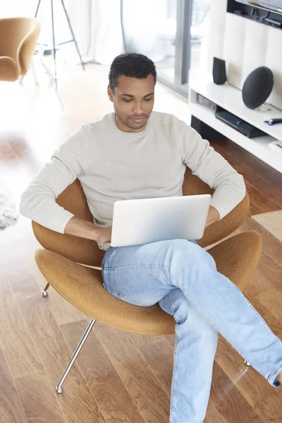 Giovane uomo che utilizza il suo computer portatile — Foto Stock