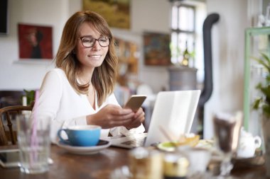 dizüstü bilgisayar önünde bir kafede oturan kadın 