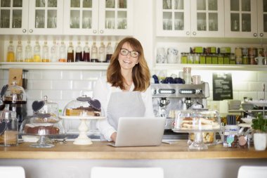 dükkan sahibi bir dizüstü bilgisayar kullanarak 