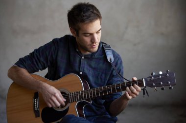 Adam gitar çalmak pratik.