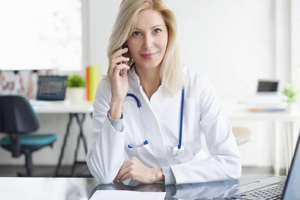 Läkare som sitter vid skrivbord — Stockfoto