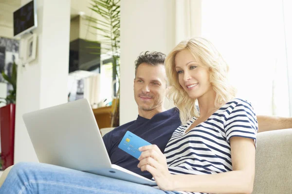 Casal usando cartão de crédito e laptop — Fotografia de Stock