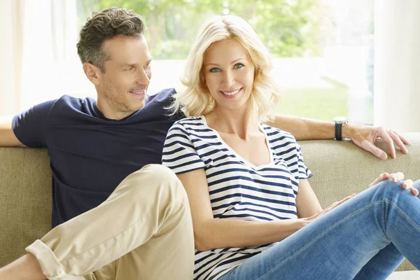 Couple sitting on couch — Stock Photo, Image