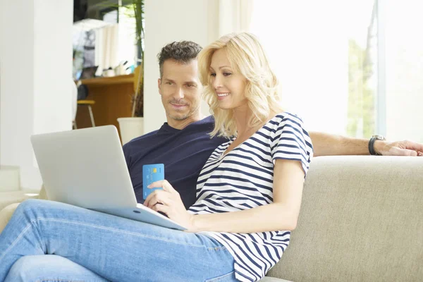 Casal usando cartão de crédito e laptop — Fotografia de Stock