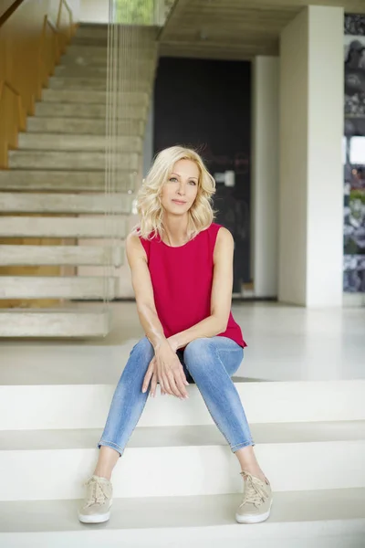 Woman sitting on modern stairs — Stock Photo, Image